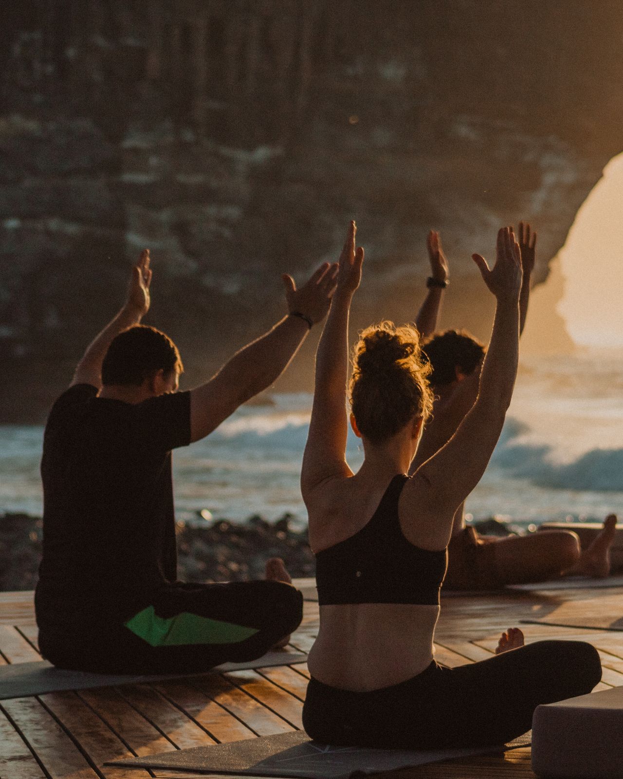 A facilitator leading a group through movement on the deck at sunrise